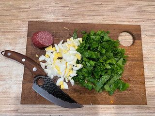 Сutting boards with products on wooden background. Fresh greens and eggs on a wooden cutting board...