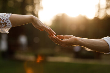 hands of romantic couple a close-up. hands men and women symbol love teamwork sunlight happy family together. silhouette hands support stroking each other. dating, romantic atmosphere