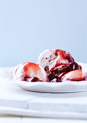 Strawberry ice cream with chocolate and cherry syrup on  chocolate brownie. Selective focus.