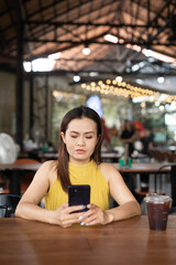 Woman in cafe using mobile phone
