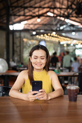 Woman in cafe using mobile phone