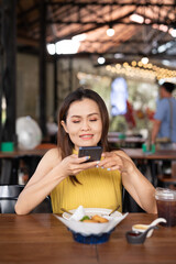 Foodie woman in cafe taking photo with mobile phone