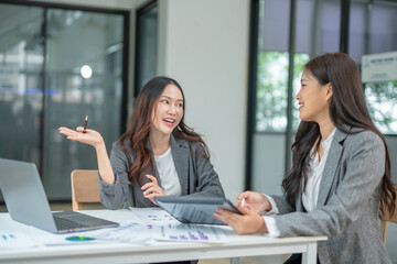 Two businesswomen are considering documents in an office.