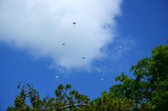 parashutists in the sky with whitr clouds