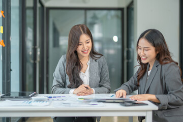 Two businesswoman hands or accountants working together on financial investment on calculator, calculating, analyzing business growth and marketing on graph.