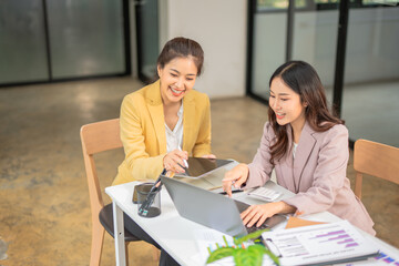 Fototapeta premium Two businesswoman hands or accountants working together on financial investment on calculator, calculating, analyzing business growth and marketing on graph.