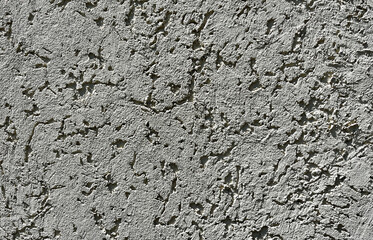 Rough gray stucco wall texture close-up. Concrete plaster surface with decorative grain pattern, ideal for backgrounds and architectural design.
