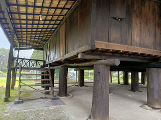 Elevated Brown Wooden House on Pillars with Stairs and Covered Porch