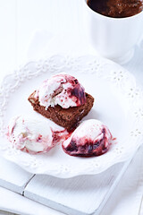 Strawberry ice cream with chocolate and cherry syrup on chocolate brownie. Selective focus.	