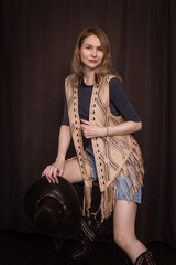 A young girl poses in a boho style suede vest.