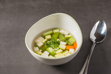 Italian minestrone soup with diced vegetables in a clear broth