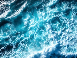 Fototapeta premium Aerial view of dynamic ocean water movement with foamy waves. Ideal for backgrounds, textures, or marine-themed designs in print and digital projects