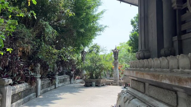 Tang Chon Cave, Marble Mountain Vietnam stunning. pagoda perched on a rocky cliff surrounded by lush green hills and a rural landscape in the distance.