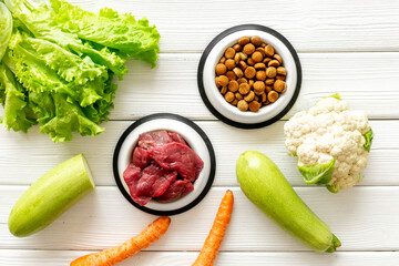Bowls with healthy pet food and ingredients, top view