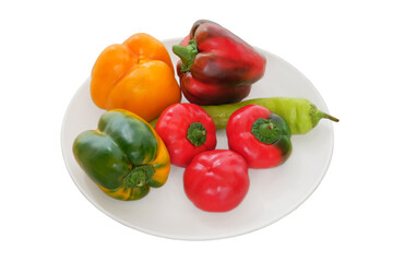 Variety of sweet and hot ripe peppers on a plate isolated on white background. Organic vegetables. Top view.