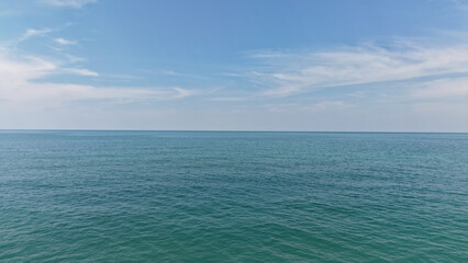 Calm turquoise sea water meeting clear blue sky on a sunny day creating a peaceful and serene seascape, ideal for backgrounds and travel concepts