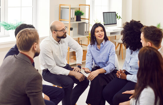 Diverse group of people, addicts sitting on chairs in circle, talking therapy meeting, discussing mental health problems, business multiethnic employees brainstorming, office team training session 
