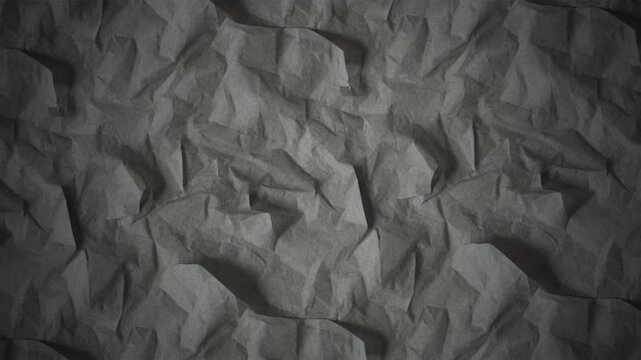 Dark grey crumpled paper texture with shadows for abstract backgrounds
