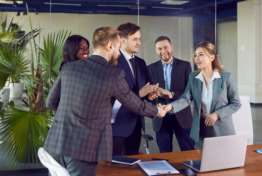Business people diverse group in office encouraging thanking happy employee for good job, shaking hand, meet new worker, getting promotion, showing respect, applause of colleagues, leader introducing 