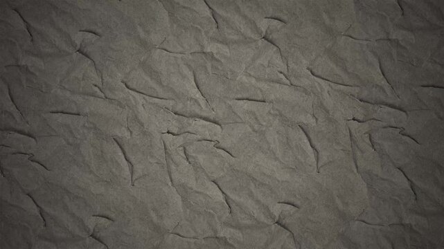 Textured dark brown paper background showing subtle folds and creases
