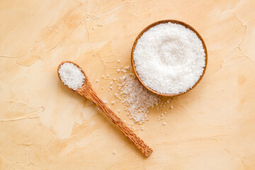 Coarse sea salt in a wooden and spoon, top view. Salt for spa, salt baths or cooking