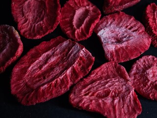 Truskawki zasuszone w plastrach na ciemnym tle, truskawkowy deseń