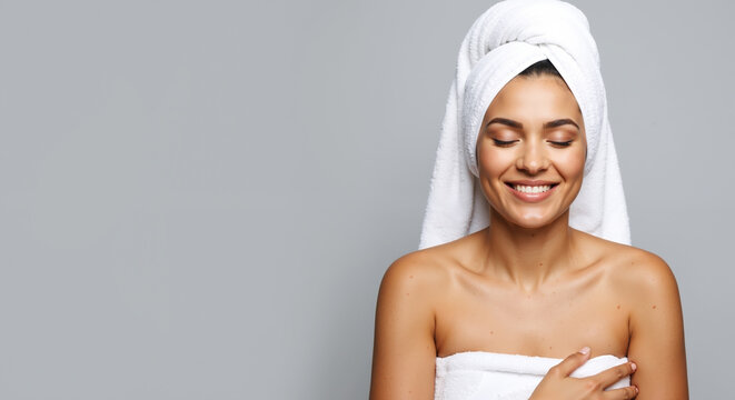 Smiling woman white towel head closed eyes relaxed spa treatment. Happy female after shower bathroom wellness routine. Self care beauty relaxation concept. Spa services vertical banner