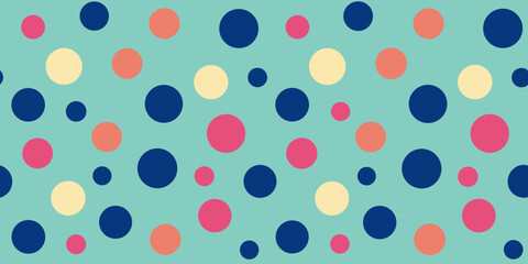 Fototapeta premium Colorful polka dots in navy, pink, peach, and cream on a teal background create a playful and vibrant pattern.