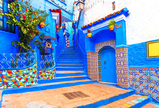 Chefchaouen, Morocco: Blue narow stairs with colourful walls and flowerpots into old walled city, or medina, North Africa