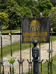 typical fence at  the garden with water fountain offering drinking water for pilgrims in front of a Portuguese home with shell sign for the St. James way in Portugal