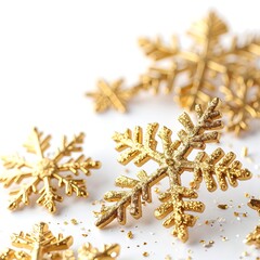 A cluster of shimmering gold snowflakes delicately scattered across a pristine white background, creating a festive and elegant winter atmosphere.