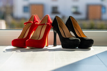 2 pairs of women's pumps in a row on the floor in front of a window