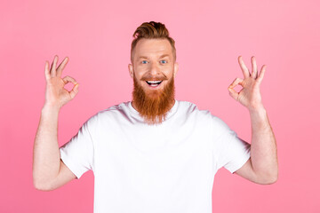 Happy red-haired man wearing white t-shirt making okay hand gesture expression over pink background
