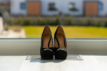 Black ladies pumps on the floor in front of a window