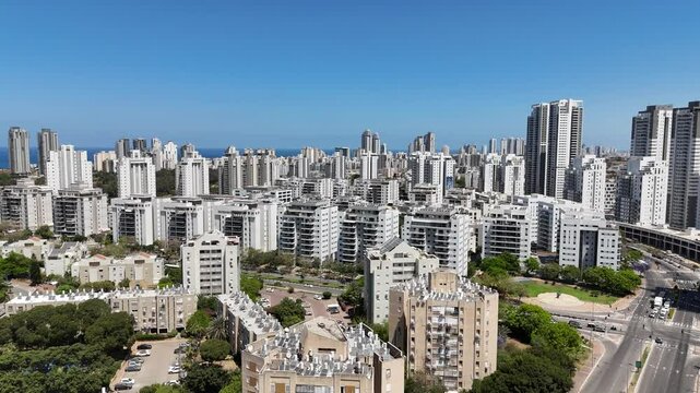 Aerial drone view of Netanya, a coastal city in central Israel. The scene showcases residential buildings, the Mediterranean Sea, cliffs, and urban development along the shoreline.