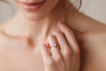 Tender and smooth image of a woman with a ring in her finger next to her collarbone