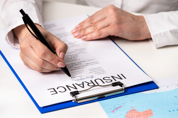 Signing Important Insurance Documents with Pen on Clipboard