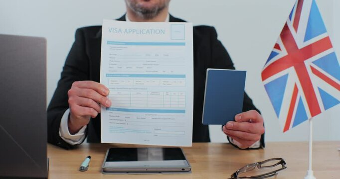 British embassy man officer showing visa application and passport, legal immigration, tourist interview.