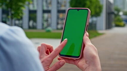 Businesswoman hands touching greenscreen smartphone standing street closeup.