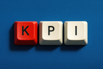 A strategic concept illustrating performance measurement and analysis is symbolized by three keyboard keys aligned horizontally on a blue matte surface