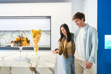 Couple choosing kitchen countertop in modern furniture showroom