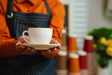 Barista in coffee shop preparing espresso drinks, working with coffee machine in a comfortable indoor atmosphere, representing small business and service.