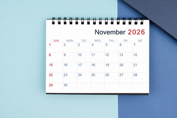 November 2026 monthly desk calendar for 2025 year on blue background.