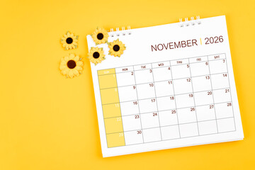 2026 November desk calendar and sunflowers on yellow background, Position with copy space.