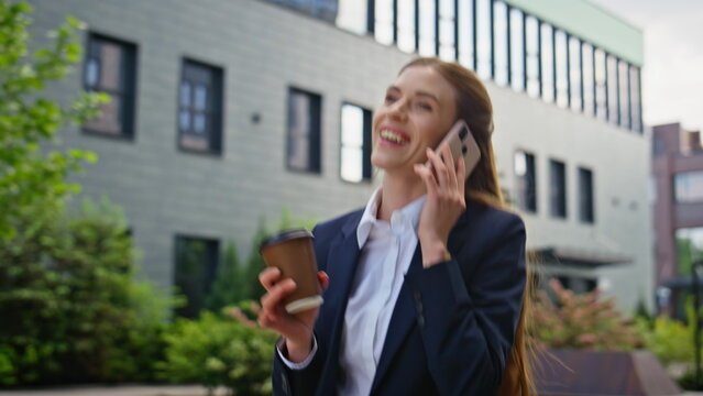 Joyful entrepreneur chatting mobile phone drinking coffee on go closeup. 