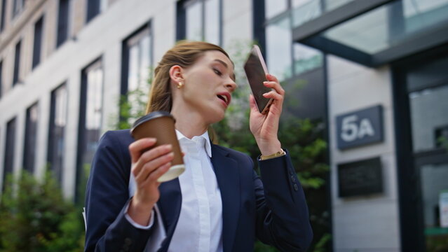 Overwhelmed businesswoman talking smartphone hurrying work with coffee closeup
