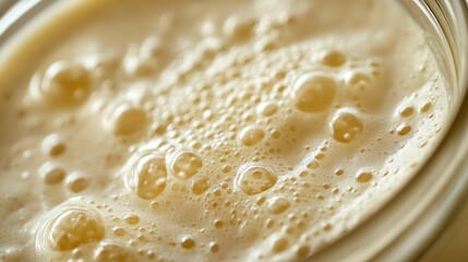 Bubbling sourdough starter in a glass container showcasing fermentation process