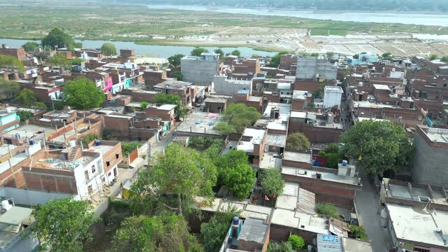 An aerial panning footage of a sprawling city along the river in Lucknow,India.