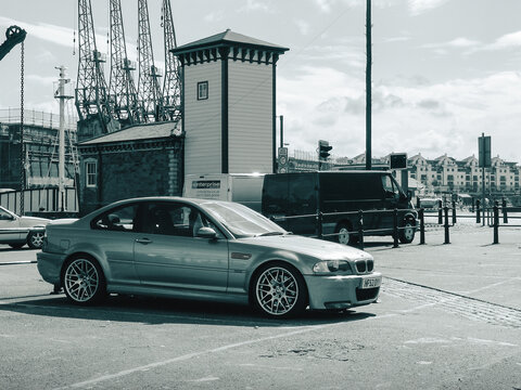silver BMW M3 CSL on a wharf. Side view of german sports coupe from early 2000s - monochrome image. Bristol, UK - July 10 2008.