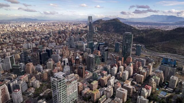Santiago, Chile &ndash; May 23, 2024: Aerial drone footage flying forward over the skyline with Costanera Center, San Crist&oacute;bal Hill and the Andes mountains under a bright sky.